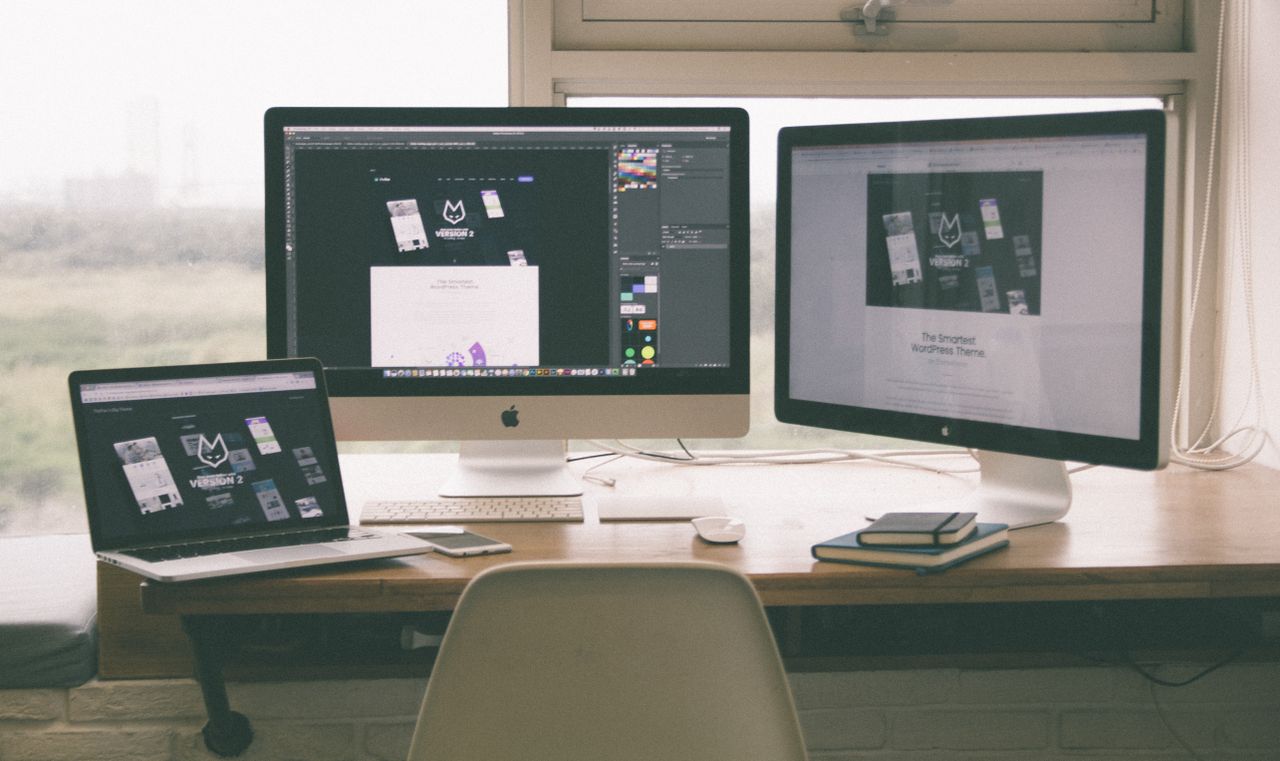 services-01 Sleek, productive workspace with several monitors, a laptop, and a smartphone, highlighting a web design project.